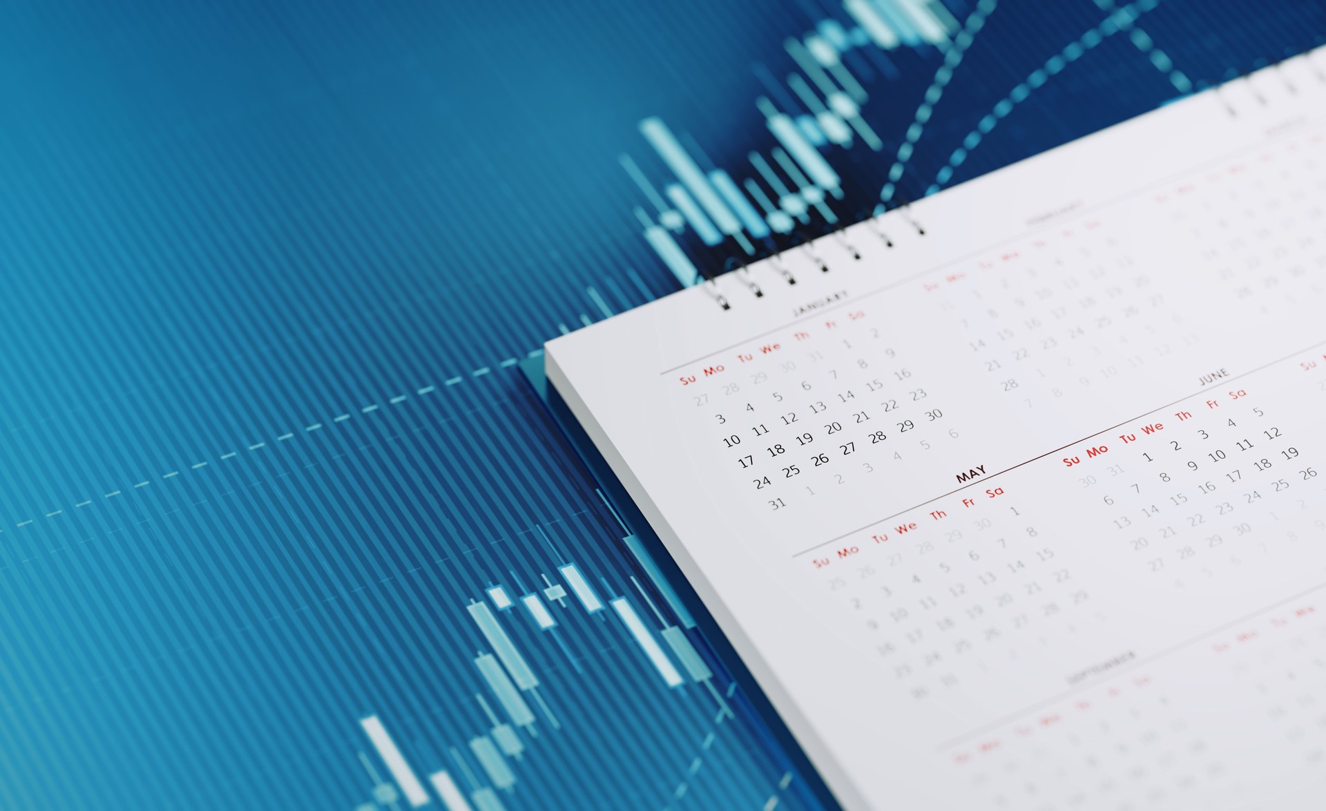 Investment And Financial Planning Concept -  White Calendar Sitting On Blue Financial Graph Background